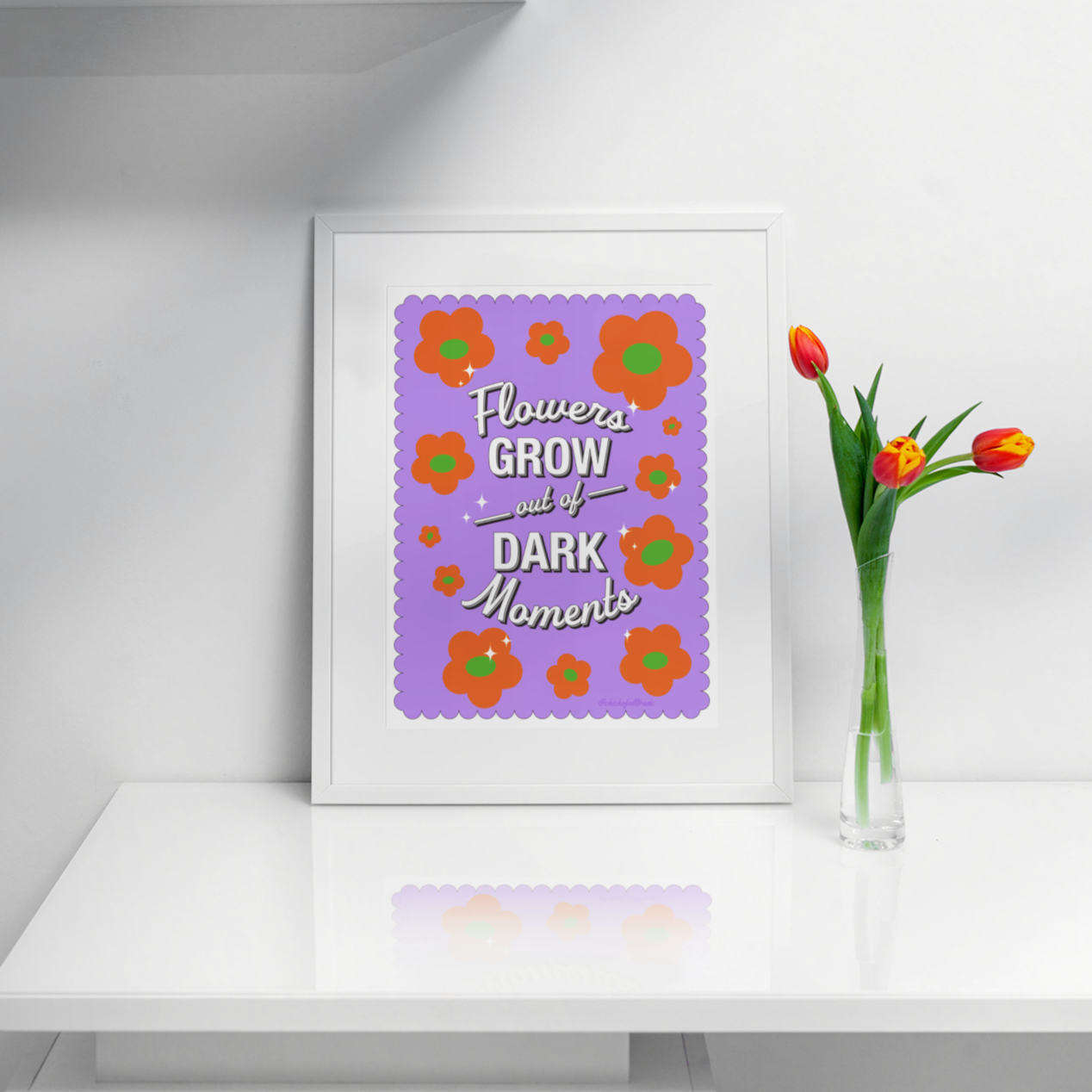 Framed artwork with floral design and text on a white shelf with decorative items.